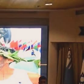טל כרמל מרצה לצד שקופית על סיום הספרטתלון